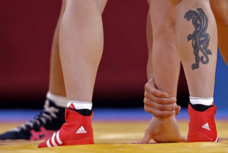 Image: Hungary's Marianna Sastin (with tattoo) fights with Ukraine's Yuliya Ostapchuk on the Women's 63Kg Greco-Roman wrestling at the ExCel venue during the London 2012 Olympic Games